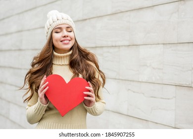 Beautiful Smiling Brunette Woman In Hat. Winter Season. With Red Heard.