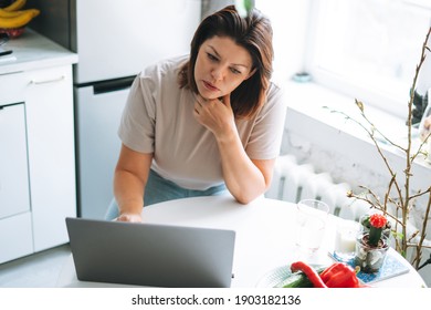 Beautiful Smiling Brunette Young Woman Plus Size Body Positive Using Laptop In Kitchen At Home