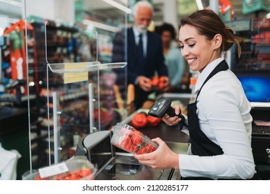 Beautiful smiling cashier working at a grocery store. - Shutterstock ID 2120285177
