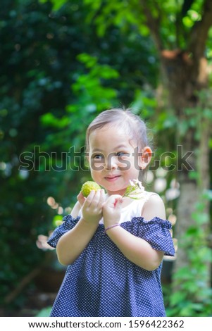 Beautiful smiling cute portrait of happy child girl,On the hands were flowers and bergamot balls according to her imagination.