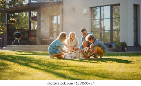 Beautiful Smiling Family of Four Cuddling Happy Golden Retriever Dog on the Backyard Lawn. Idyllic Family Cuddling Loyal Pedigree Dog Outdoors in Summer House Backyard. - Shutterstock ID 1853535757