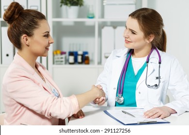 Beautiful Smiling Female Medicine Doctor Shaking Hands With Patient. Partnership, Trust And Medical Ethics Concept. Handshake With Satisfied Client. Thankful Handclasp For Excellent Treatment