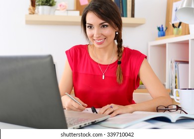 Beautiful Smiling Female Student Using Online Education Service. Young Woman In Library Or Home Room Looking In Laptop Display Watching Training Course. Modern Study Technology Concept