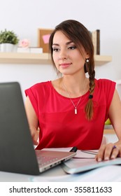 Beautiful Smiling Female Student Using Online Education Service. Young Woman In Library Or Home Room Looking In Laptop Display Watching Training Course. Modern Study Technology Concept