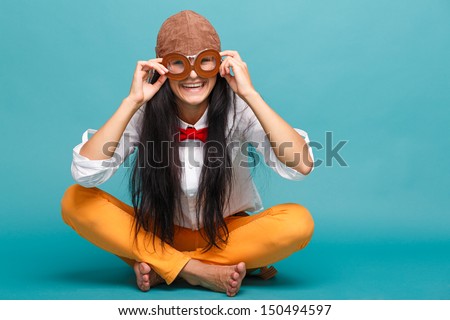 Beautiful smiling girl in helmet on a green background. Vintage pilot (aviator) concept
