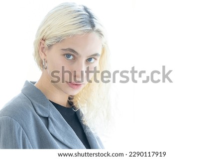 Beautiful smiling happily caucasian businesswoman in suit jacket using tablet, smart phone in modern office in city on springtime in sunny day, joyful, relaxing moment. Technology, business concept.