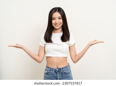 Beautiful smiling happy young asian woman in white shirt. Charming female lady open hands palm up holding something on isolated white background. Asian cute Pretty people looking copy space.