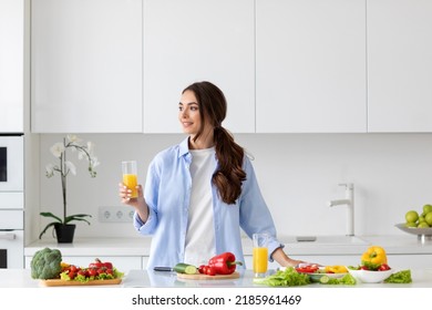 Beautiful Smiling Healthy Woman With Juice In Her Hands While Preparing Vegan Food. Proper Nutrition.