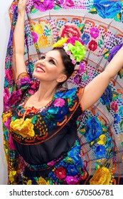 beautiful smiling mexican woman in traditional mexican dress hands up holding the skirt as a background like peacock