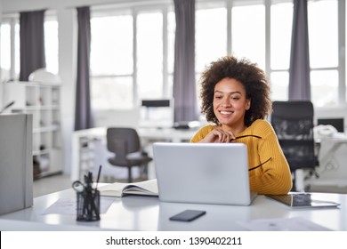 Beautiful smiling mixed race businesswoman dressed casual sitting in office and using laptop. - Shutterstock ID 1390402211
