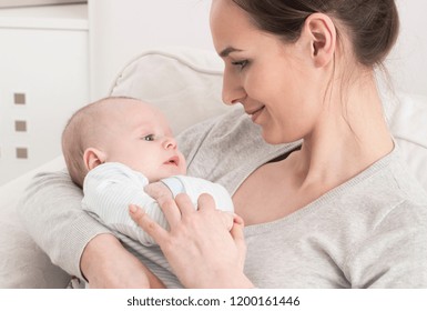 Beautiful smiling mother holding little baby in her arms