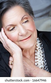 Beautiful Smiling Older Woman With Short Black And Grey Hair And Pearl Necklace In Her 70s