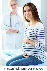 Beautiful smiling pregnant woman with the doctor at hospital - Shutterstock ID 2053432790