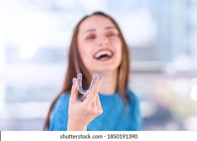 Beautiful smiling Turkish woman is holding an invisalign bracer, includes copy space