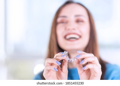 Beautiful smiling Turkish woman is holding an invisalign bracer, includes copy space