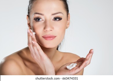 Beautiful Smiling Woman Applying Cream On Face