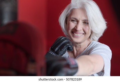 Beautiful Smiling Woman Boxing Punching Bag.