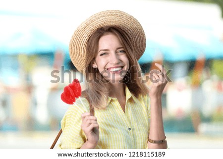 Beautiful smiling woman with candies on city street