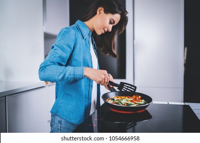 Beautiful Smiling Woman Cooking In Kitchen At Home Fresh Vegetables In Frying Pan On Electric Stove, Healthy Food Lifestyle