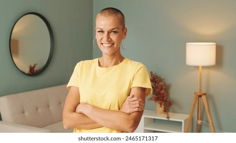 Beautiful smiling woman crossing arms and looking at camera in living room - Powered by Shutterstock