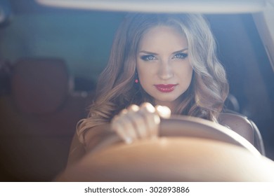 Beautiful Smiling woman driving car, attractive girl sitting in automobile, outdoors summer portrait.