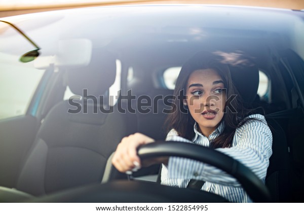 Beautiful\
Smiling woman driving car, attractive girl sitting in automobile,\
outdoors summer portrait. Young woman driving her car. Young woman\
in car driving seat looking ahead, close\
up