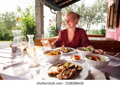 Beautiful Smiling Woman Eating A Meal On A Restaurant Porch In The Summer	