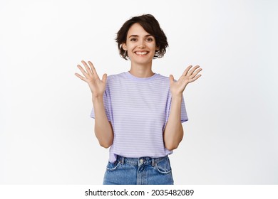 Beautiful smiling woman, girl clap hands and looking pleased, celebrating, applause and congratulate with win, proud, praise someone, standing over white background.