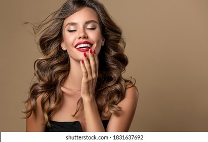 Beautiful smiling woman with long wavy hair .  Girl curly hairstyle  and red manicure nails . Beauty ,makeup and cosmetics . - Shutterstock ID 1831637692