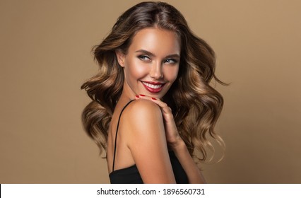 Beautiful Smiling Woman With Long Wavy Hair .  Girl Curly Hairstyle  And Red Manicure Nails . Beauty ,makeup And Cosmetics .