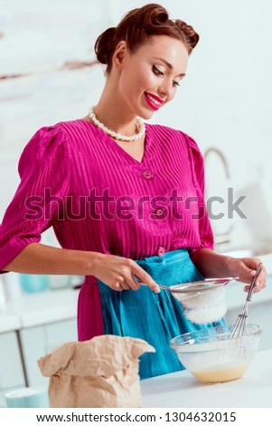 Beautiful smiling woman mixing ingredients for dough