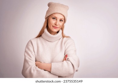 Beautiful smiling woman standing at isolated white background. Blond haired woman wearing knit hat and turtleneck sweater. Copy space.  - Powered by Shutterstock