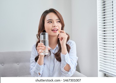 Beautiful Smiling Woman Taking Vitamin Pill. Dietary Supplement 