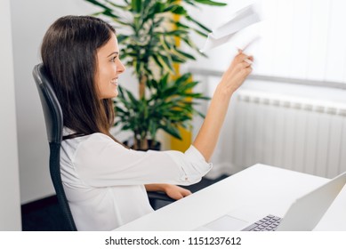 Beautiful Smiling Woman Tossing Paper Airplane