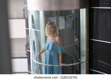 Beautiful Smiling Woman In Transparent Glass Elevator