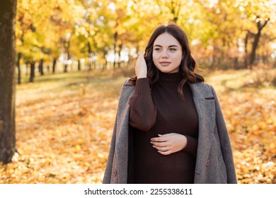 Beautiful smiling woman walking outdoors in autumn looking at camera. Copy space - Shutterstock ID 2255338611