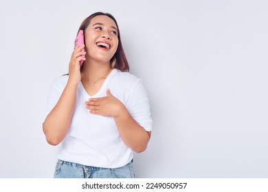 Beautiful smiling young Asian girl wearing casual white t-shirt talking on mobile phone with friend, looking at empty space isolated on white background. People lifestyle concept - Shutterstock ID 2249050957