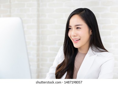 Beautiful Smiling Young Asian Woman In White Suit Working On Computer At The Office