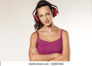 beautiful smiling young brunette posing with anti loud headset