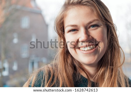 Beautiful and smiling young Dutch woman with a genuine smile is feeling positive and happy.  