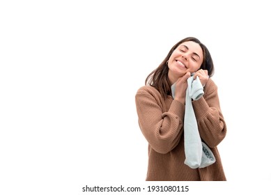 Beautiful Smiling Young Pregnant Woman Is Holding A Onesie, Tight To Her Chest, With Love