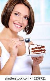 The Beautiful Smiling Young Woman With A Cake Slice On A Plate