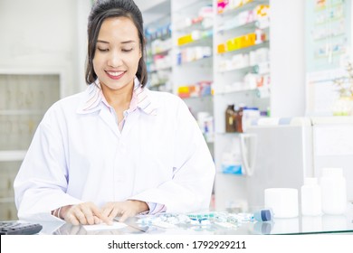 Beautiful smiling young woman pharmacist doing her work in pharm