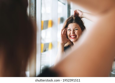 Beautiful Smiling Young Woman Plus Size Body Positive In Black Evening Dress Make Hair Style Near Mirror At Beauty Studio