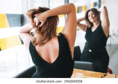 Beautiful Smiling Young Woman Plus Size Body Positive In Black Evening Dress Make Hair Style Near Mirror At Beauty Studio