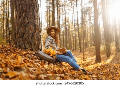 Beautiful smiling young woman student sitting and reading book at autumn park fall yellow foliage leaves. Concept of enjoying nature. - Powered by Shutterstock