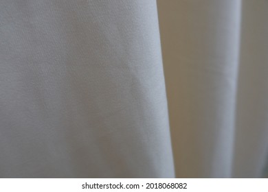 Beautiful And Smooth Bright Clothe Is Hanging In A Low Light Room.