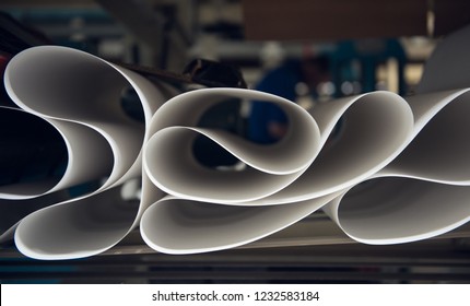 A beautiful smooth clean paper roll machine creating a continuous sheet of white freshly made paper for painting, wallpaper and wrapping. Industrial paper roll folds on industrial machinery. - Shutterstock ID 1232583184