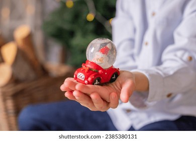 Beautiful snow globe with santa claus and snowflakes inside the sphere in the child hands, christmas decoration gift close up. winter holidays mood - Powered by Shutterstock