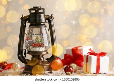 Beautiful snow globe in vintage lantern, gift boxes and Christmas decor on table. Bokeh effect - Powered by Shutterstock